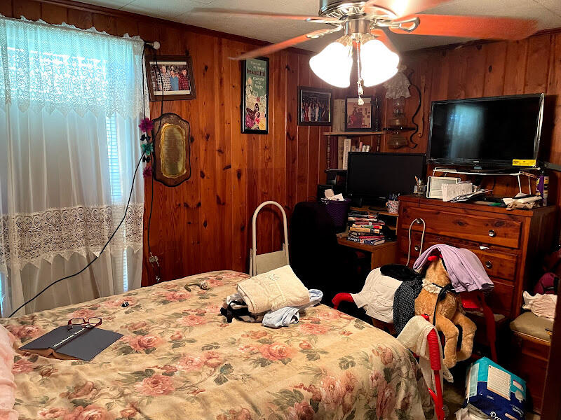 5161 Griffith Mill Road Holt, FL 32564 - Photo 18 of 25 a bedroom with a bed and a flat tv screen on dresser
