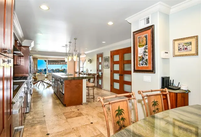 a kitchen with stainless steel appliances granite countertop a stove top oven a sink dishwasher a dining table and chairs with wooden floor