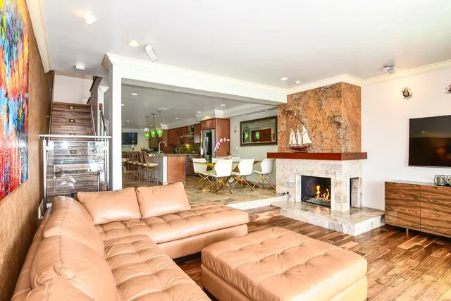 a living room with furniture a flat screen tv and a fireplace