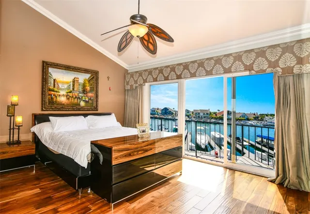 a bedroom with a bed and a large window with the view of balcony