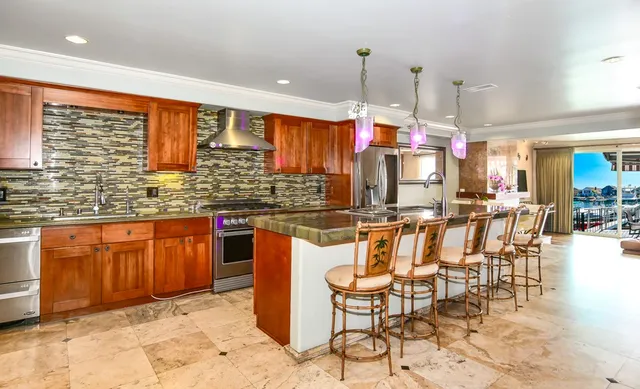 a kitchen with stainless steel appliances granite countertop a sink and a refrigerator
