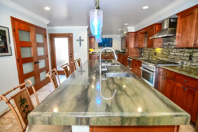 a kitchen with stainless steel appliances granite countertop a stove a sink and a microwave