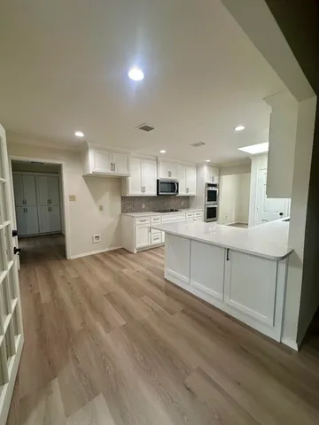an empty room with windows and ceiling fan view