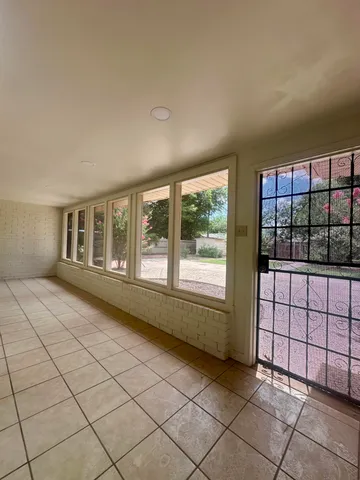 an empty room with a ceiling fan and window