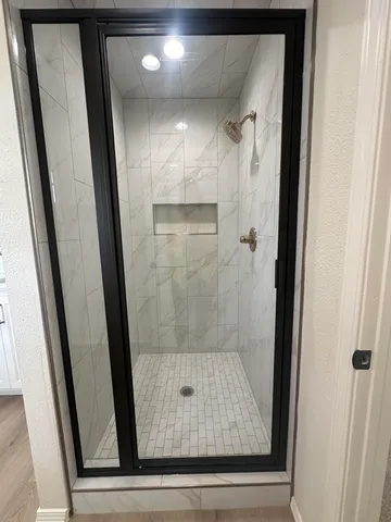 an empty room with wooden floor and mirror