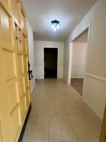 an empty room with wooden floor a fireplace and windows