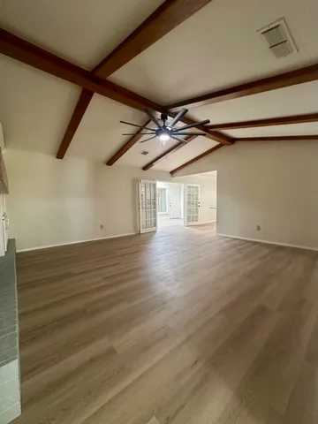 a large kitchen with stainless steel appliances a large counter top a stove and a refrigerator