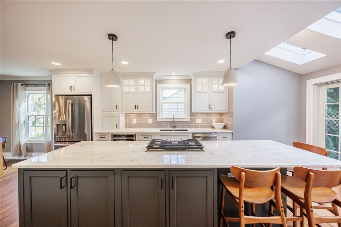 387 Kilbourn Road Rochester, NY 14618 - Photo 4 of 42 A spacious QUARTZITE countertop island under a skylight defines this modern kitchen.
