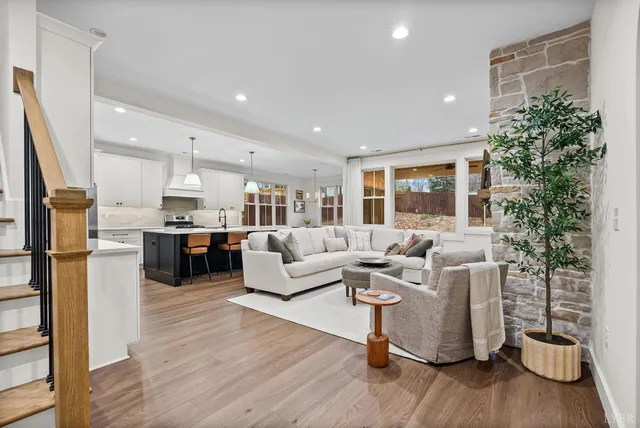 a living room with furniture a fireplace and a chandelier