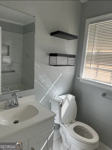 a white toilet sitting next to a bathroom sink