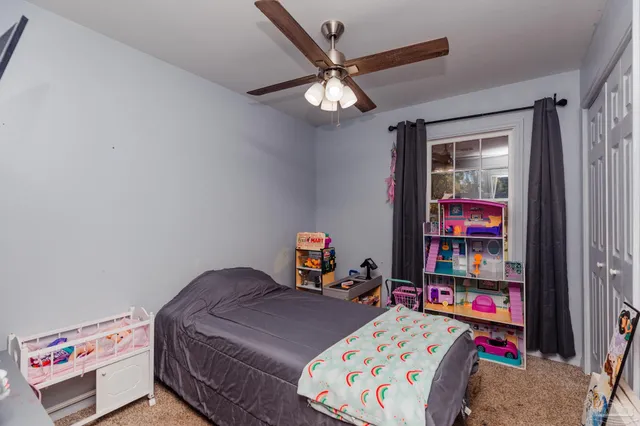 a bedroom with bed and book shelf