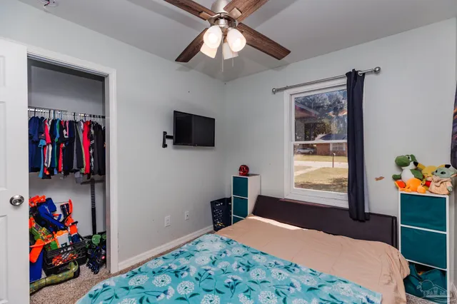 a bedroom with a bed and a flat screen tv