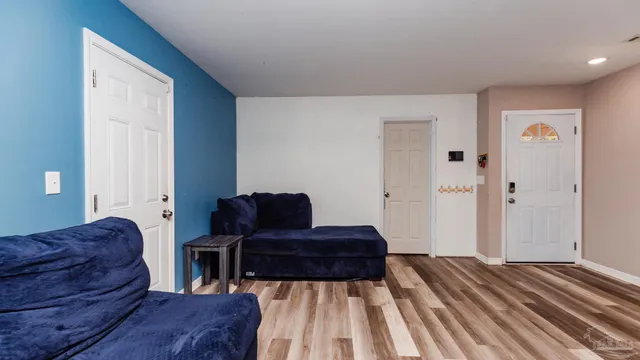 a living room with a couch and a dresser with wooden floor