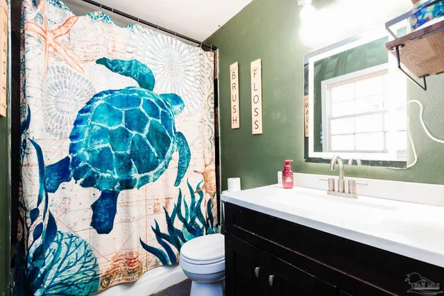 a bathroom with a sink and mirror with toilet