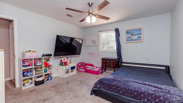 a bedroom with furniture and a flat screen tv