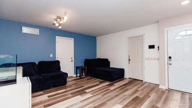 a living room with furniture and a wooden floor