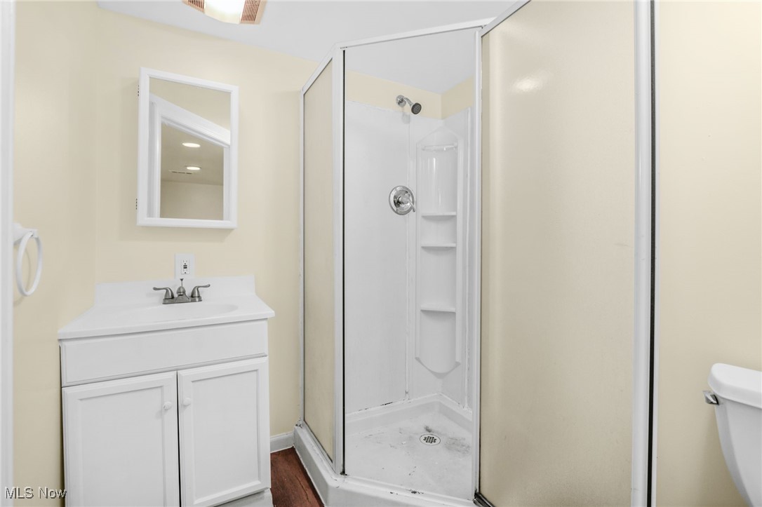 3205 George Avenue Cleveland, OH 44134 - Photo 27 of 32 Full bathroom featuring a stall shower, vanity, and wood finished floors