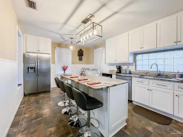 a kitchen with stainless steel appliances granite countertop a sink a stove a refrigerator and cabinets