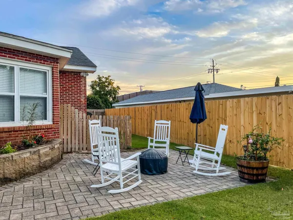 a view of a patio with table and chairs potted plants with wooden fence