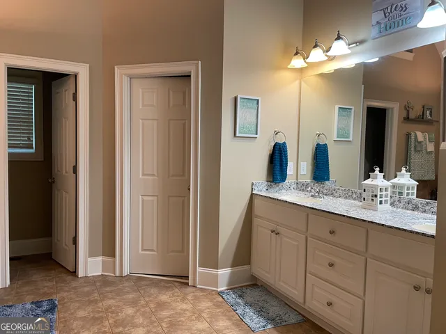 a bathroom with a granite countertop sink a mirror and a shower