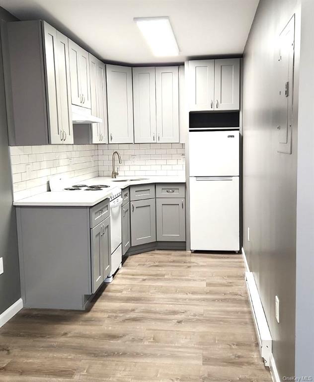 a kitchen with a sink a refrigerator and cabinets