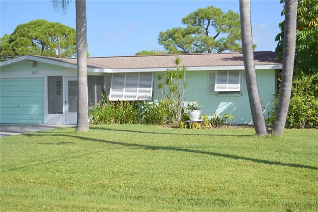a front view of a house with a garden and plants