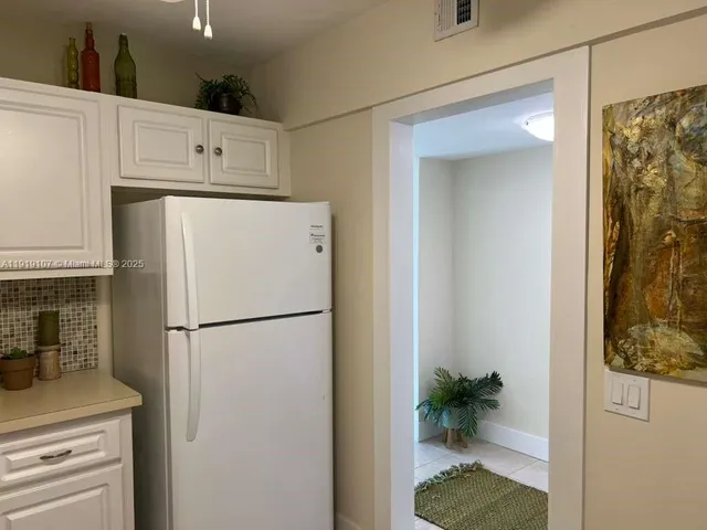 a white refrigerator freezer sitting inside of a kitchen