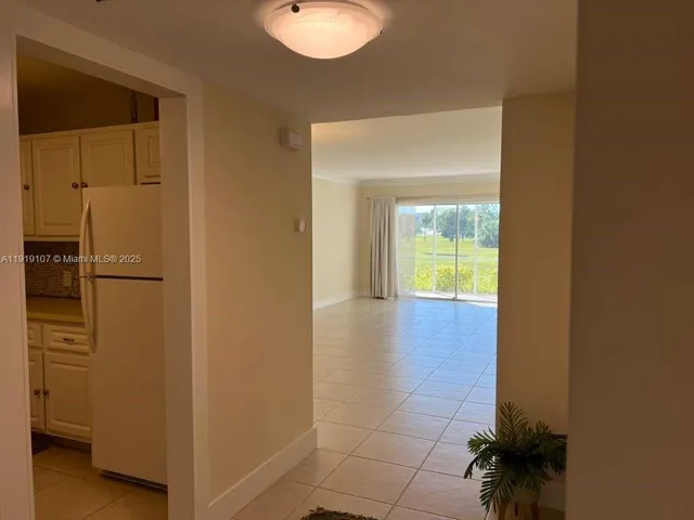 a view of a hallway with wooden floor and a bathroom