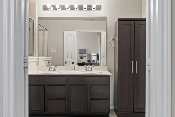 a bathroom with a double vanity sink and a mirror