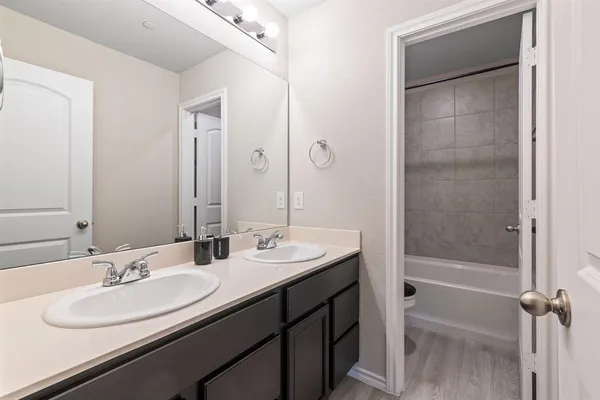 a bathroom with a double vanity sink mirror double and shower
