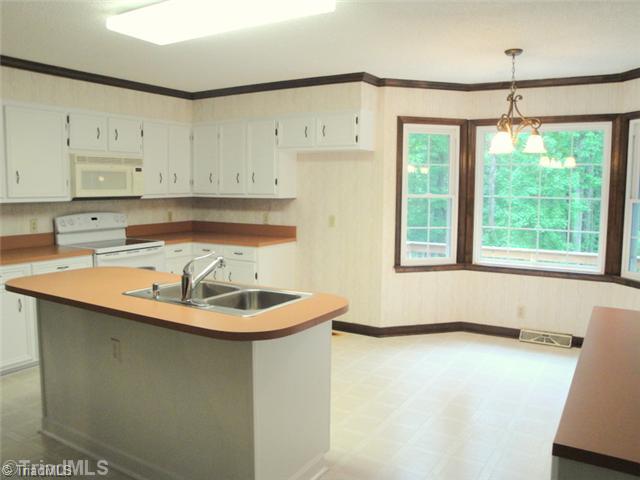 398 Farmstead Road Winston-Salem, NC 27107 - Photo 6 of 16 Kitchen. Bright and Cheery, you ll love preparing meals in this room...the large working island houses the dishwasher and there is a pantry in addition to all of the cabinets.