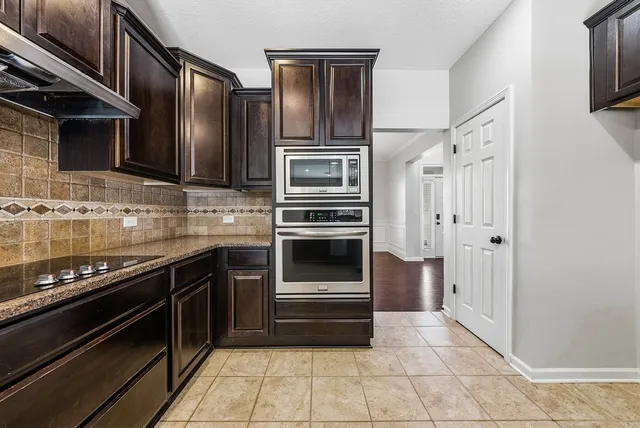 a kitchen with stainless steel appliances granite countertop a sink stove and oven