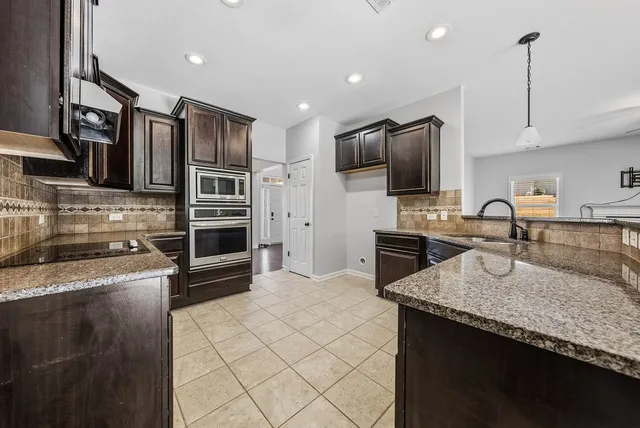 a kitchen with granite countertop stainless steel appliances and counter space