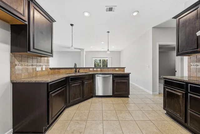 an empty room with wooden floor chandelier fan and windows