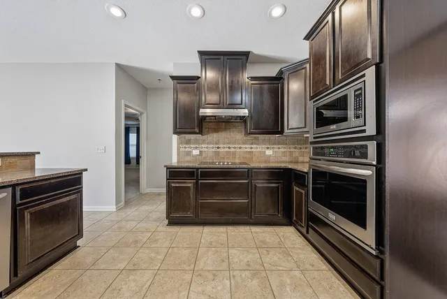an empty room with windows and fireplace
