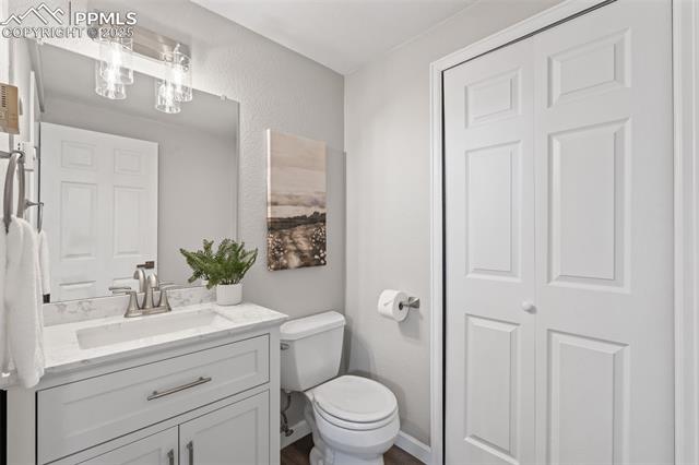 15535 Softwood Road Elbert, CO 80106 - Photo 33 of 47 Half bath featuring vanity, a textured wall, and a closet