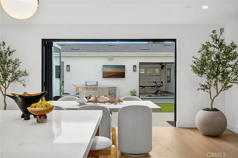 a dining room with furniture and a potted plant