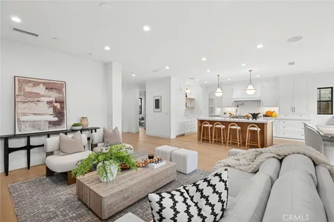 a living room with furniture kitchen view and a table
