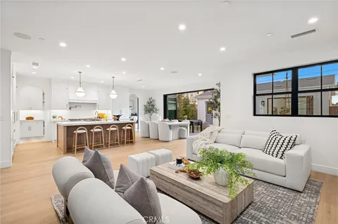 a living room with furniture kitchen view and a large window