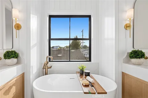 a bathroom with a tub sink and mirror