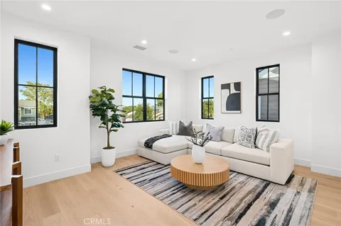 a living room with furniture potted plant and windows