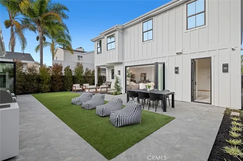 a view of a patio with table and chairs potted plants and large tree