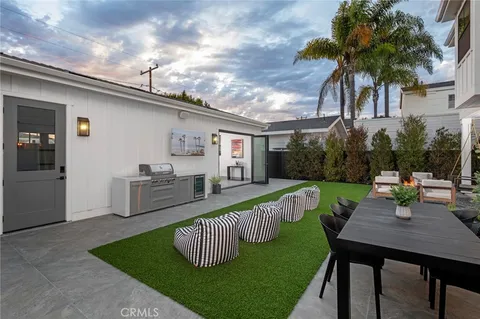 a view of a patio with table and chairs potted plants and palm tree