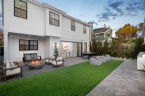 a front view of a house with garden and trees