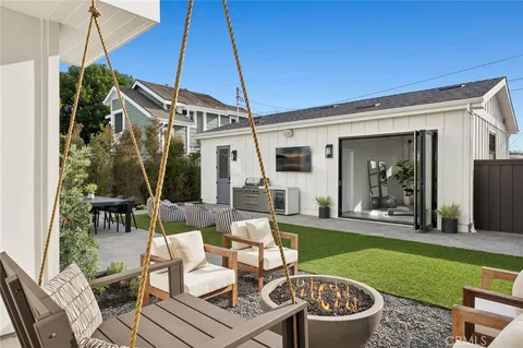 a view of a patio with couches table and chairs under an umbrella