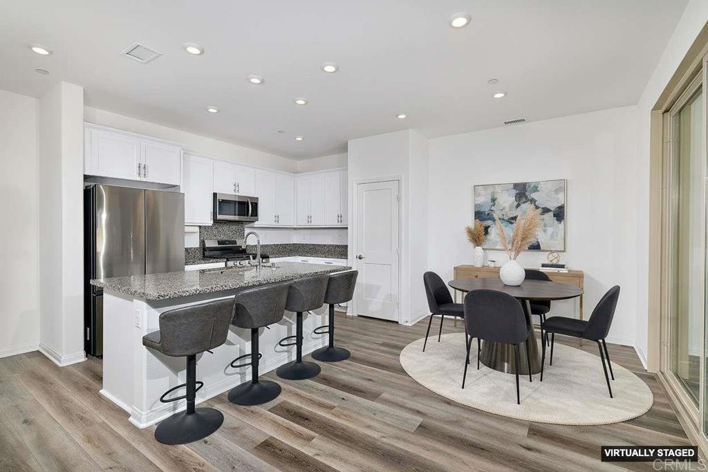 1622 Fig Tree Way Oceanside, CA 92056 - Photo 14 of 48 a view of a dining room with furniture a rug and wooden floor