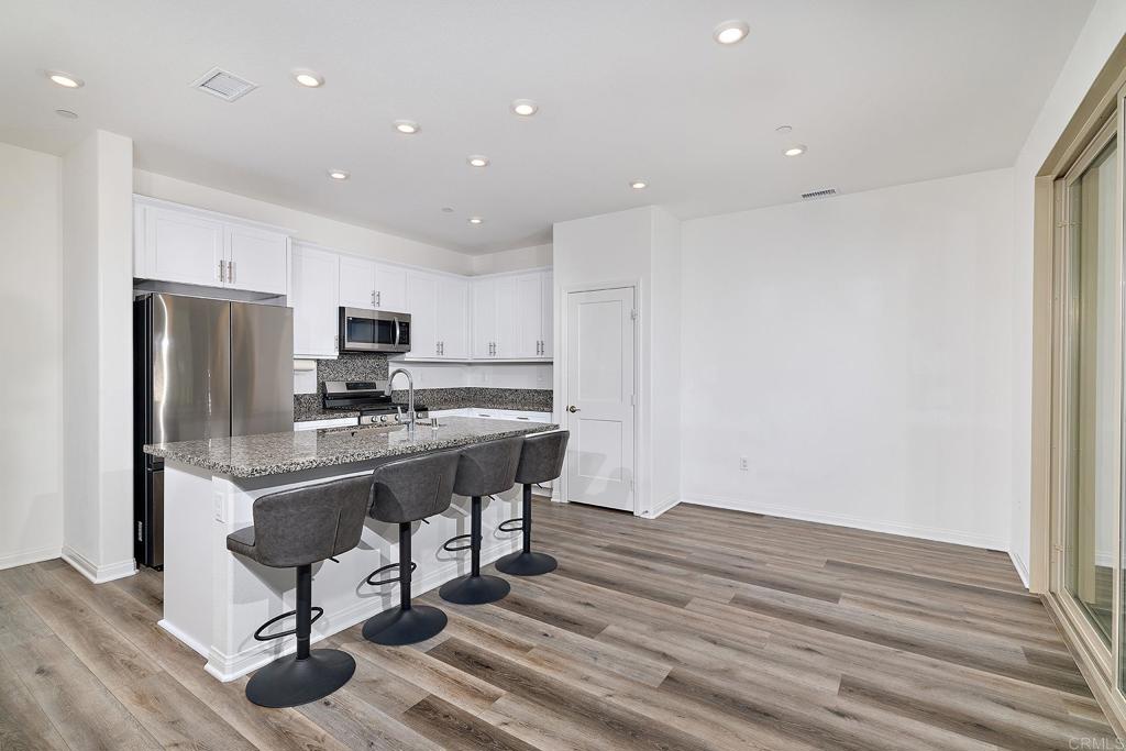 1622 Fig Tree Way Oceanside, CA 92056 - Photo 15 of 48 a view of kitchen with refrigerator microwave and wooden floor