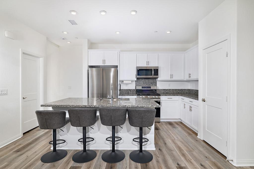 1622 Fig Tree Way Oceanside, CA 92056 - Photo 16 of 48 a kitchen with sink cabinets and wooden floor