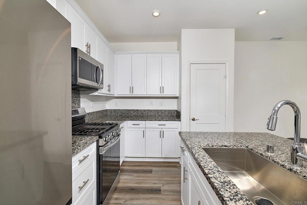 1622 Fig Tree Way Oceanside, CA 92056 - Photo 17 of 48 a kitchen with granite countertop a sink stove and cabinets