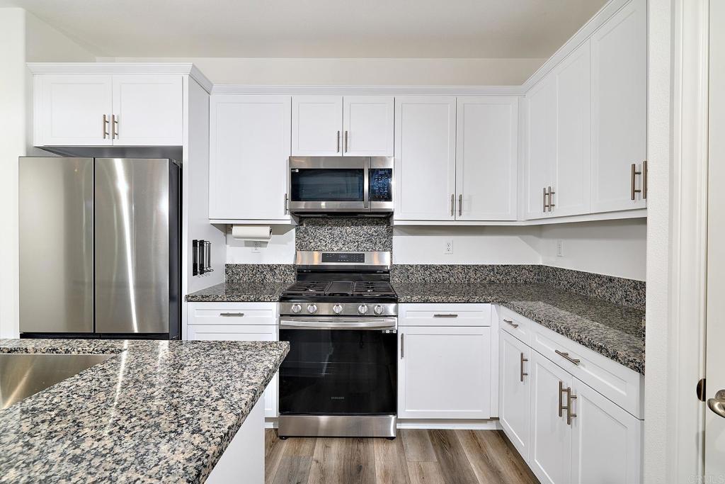 1622 Fig Tree Way Oceanside, CA 92056 - Photo 18 of 48 a kitchen with granite countertop white cabinets and stainless steel appliances